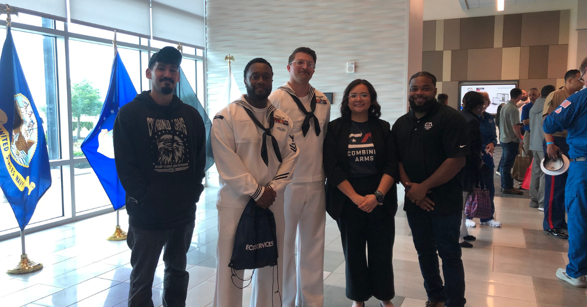 Five attendees at the Fleet Week VetConnect Career Exploration Event are standing together; two of them are wearing white marine uniform.