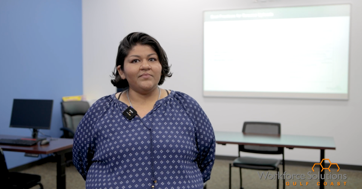 Nikita, a Career Adviser with the Conroe Workforce Solutions office stands confidently in a classroom.