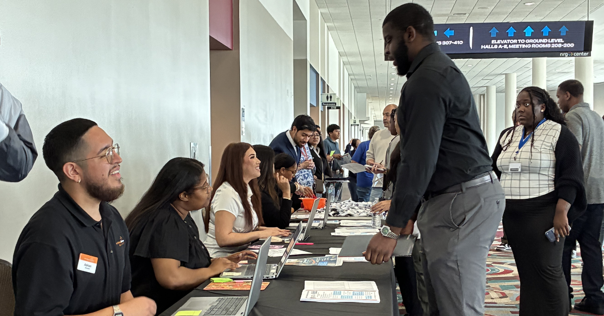 HGCY Career Exploration Job Fair A bustling registration table at a conference, with diverse attendees and staff interacting warmly.