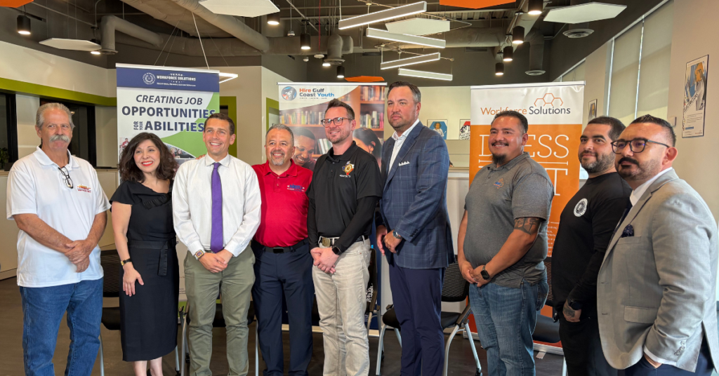 Workforce Solutions Executive Director Juliet Stipeche, next to Juan Granado, a training coordinator for the Apprenticeship Readiness Program/Multi-Craft Core Curriculum program (ARP/MC3); Paul Puente of the Houston Gulf Coast Building & Construction Trades Council; and Ryan Schuette, Business Manager for the Elevator Construction Union (IUEC 31), all standing in a Workforce Solutions office.