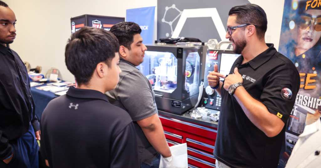 Instructor demonstrates advanced manufacturing equipment to students during a workforce training session.