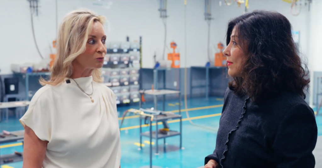 Executive Director Juliet K. Stipeche speaking with Wendy Hall, Senior Director of Communications, Culture & Community Engagement for Daikin Comfort Technologies North America, inside a Daikin facility.