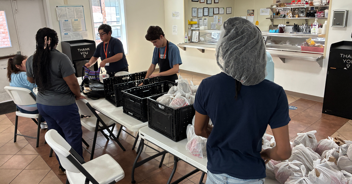 GCWF – Graphics – 2026-08-27T123728.914 Four Students wearing black volunteering at Mission of Yahweh.
