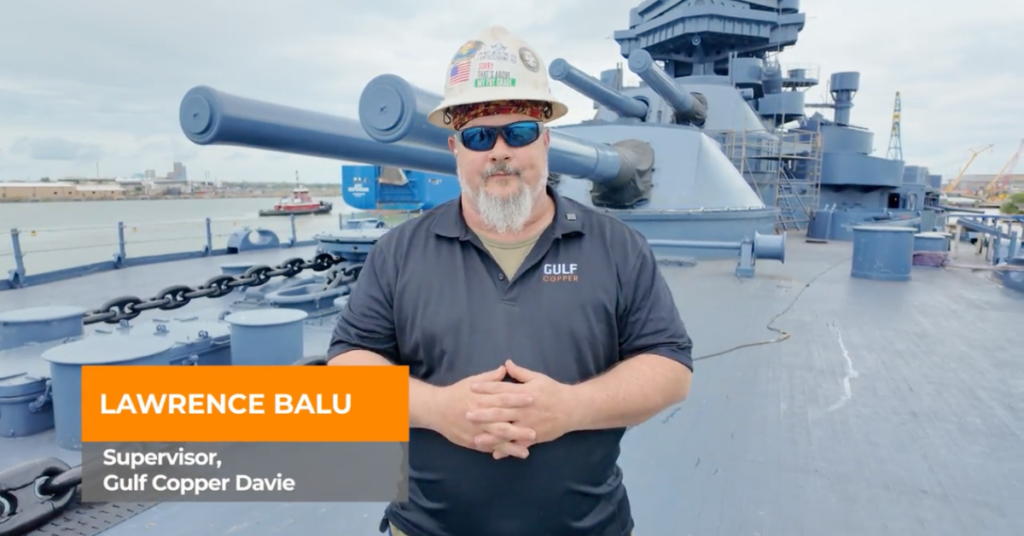 Lawrence Balu, a supervisor with Gulf Copper Davie and a U.S. Marine Corps veteran wears uniform in fornt of a ship.