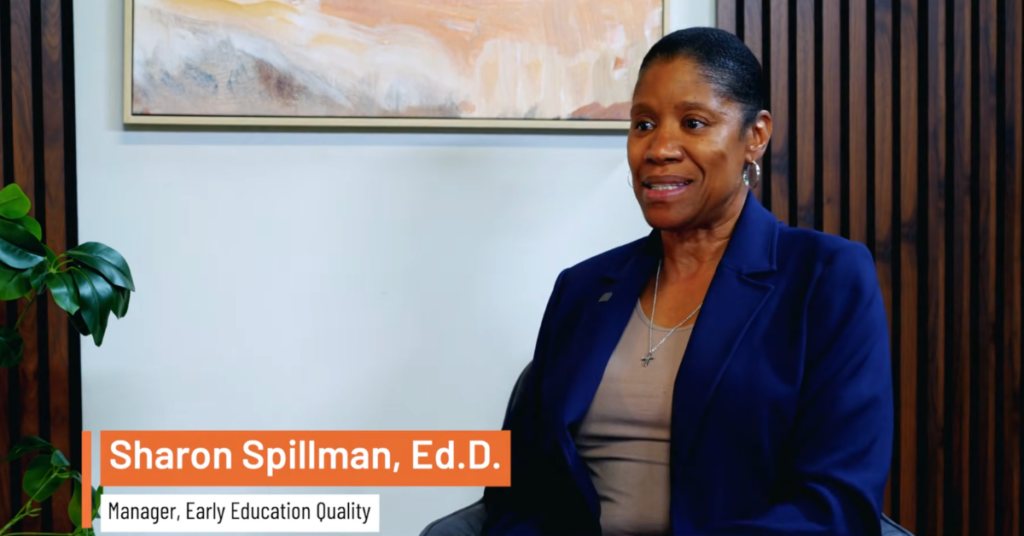 Dr. Sharon Spillman at the Workforce Solutions podcast. The setting is an office with striped wooden paneling.