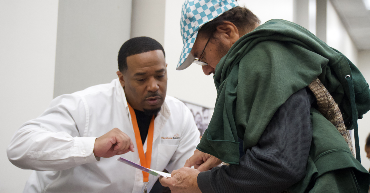 Workforce Solutions Career Assistance Workforce Solutions Gulf Coast representative assisting an attendee with information during a community workforce event.